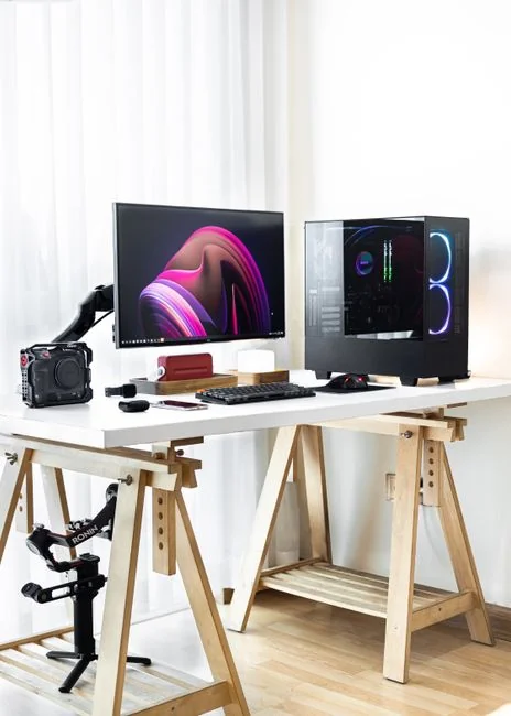 A tidy office setup with a laptop showing social media, papers, and a plant for event promotion.